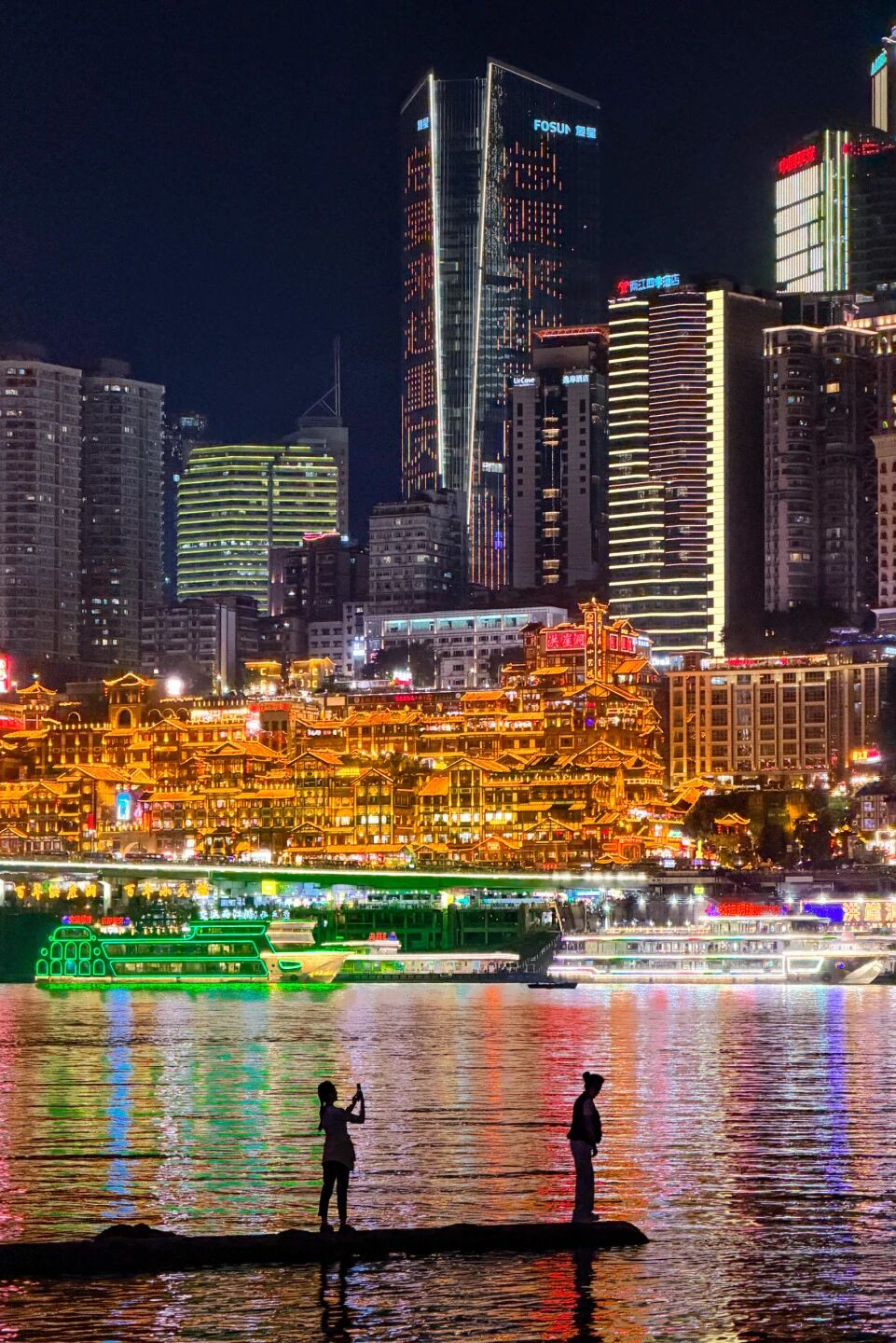 Hongya Cave lit up at night above the Jialing River in Chongqing