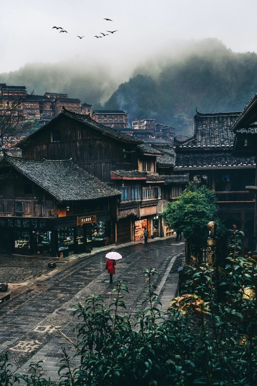 Timber stilt houses of the Xijiang Miao villages in the mist