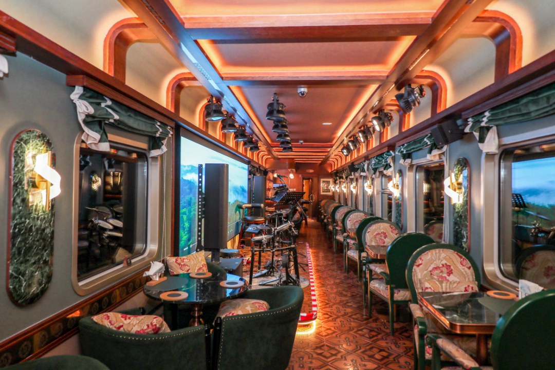 The jazz bar car aboard the Lindou Express with warm lighting and live music stage