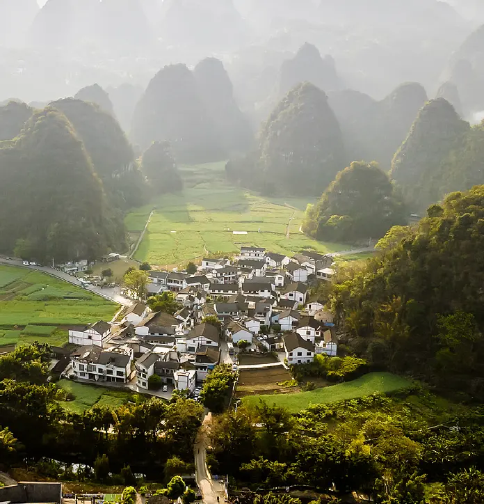 Qian-Gui Frontier - karst peaks rising over a village in the rice fields of Guangxi